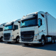 Ligne de camions puissants 33 tonnes dans une cour logistique ensoleillée
